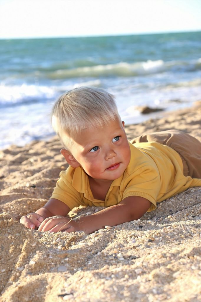 Bambino biondo sdraiato sulla spiaggia, copertina dell'articolo sulla protezione solare
